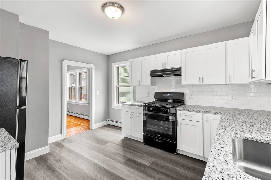 100 Weetamoe Street Fall River, MA 02720 - Photo 5 of 42 a kitchen with granite countertop a stove a sink and a refrigerator