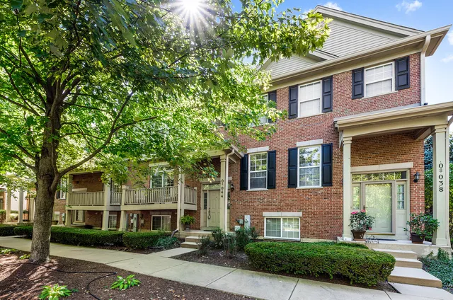 front view of a brick house with a yard