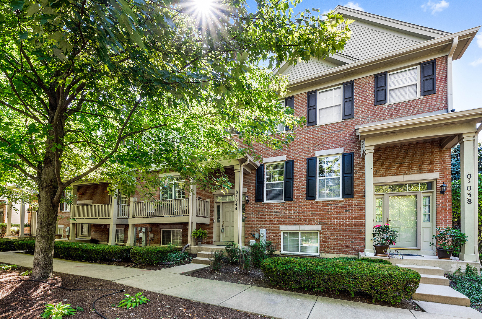 front view of a brick house with a yard