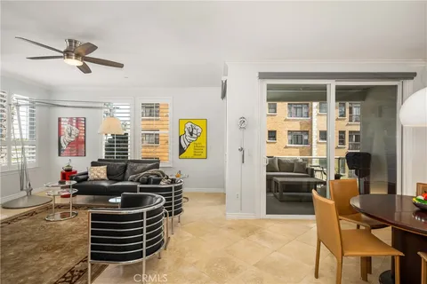 a kitchen with stainless steel appliances a refrigerator a stove a sink dishwasher and a dining table with wooden floor