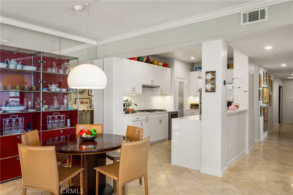 1000 East Ocean Boulevard, Unit 613 Long Beach, CA 90802 - Photo 18 of 65 a kitchen with stainless steel appliances a refrigerator a stove a sink dishwasher and a dining table with wooden floor