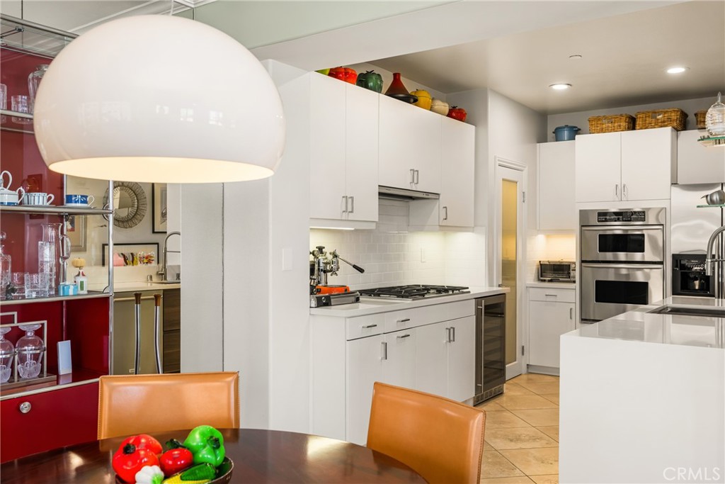 1000 East Ocean Boulevard, Unit 613 Long Beach, CA 90802 - Photo 19 of 65 a kitchen with stainless steel appliances granite countertop a stove a sink a refrigerator white and white cabinets and wooden floor
