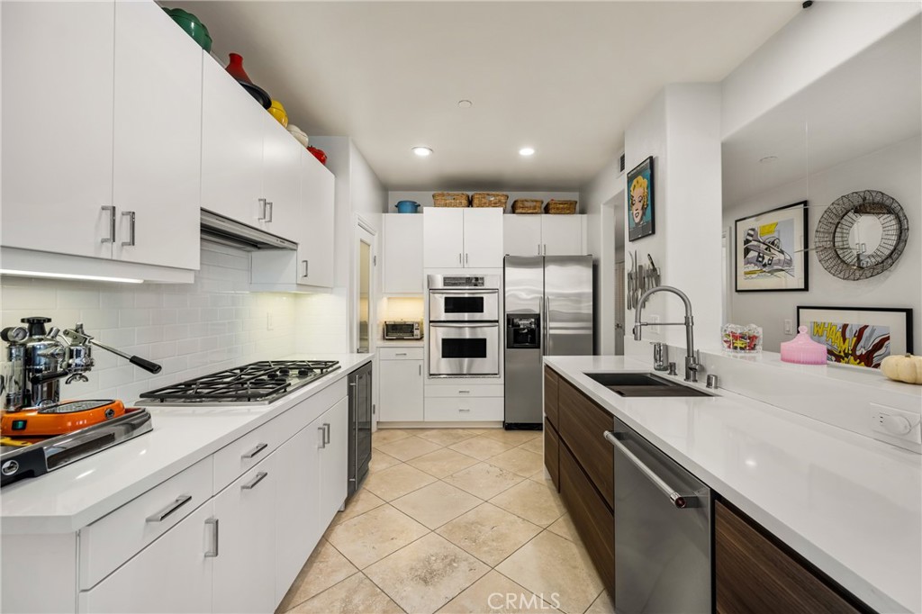 1000 East Ocean Boulevard, Unit 613 Long Beach, CA 90802 - Photo 22 of 65 a kitchen with stainless steel appliances a sink stove and cabinets