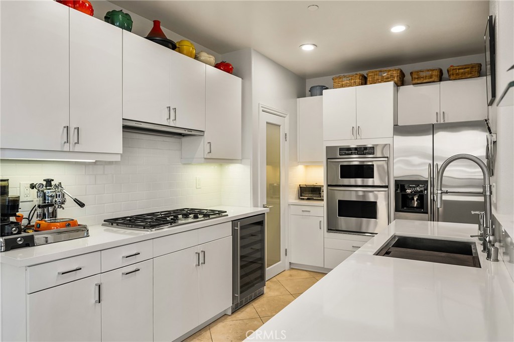 1000 East Ocean Boulevard, Unit 613 Long Beach, CA 90802 - Photo 23 of 65 a kitchen with stainless steel appliances kitchen island granite countertop a sink a stove and cabinets