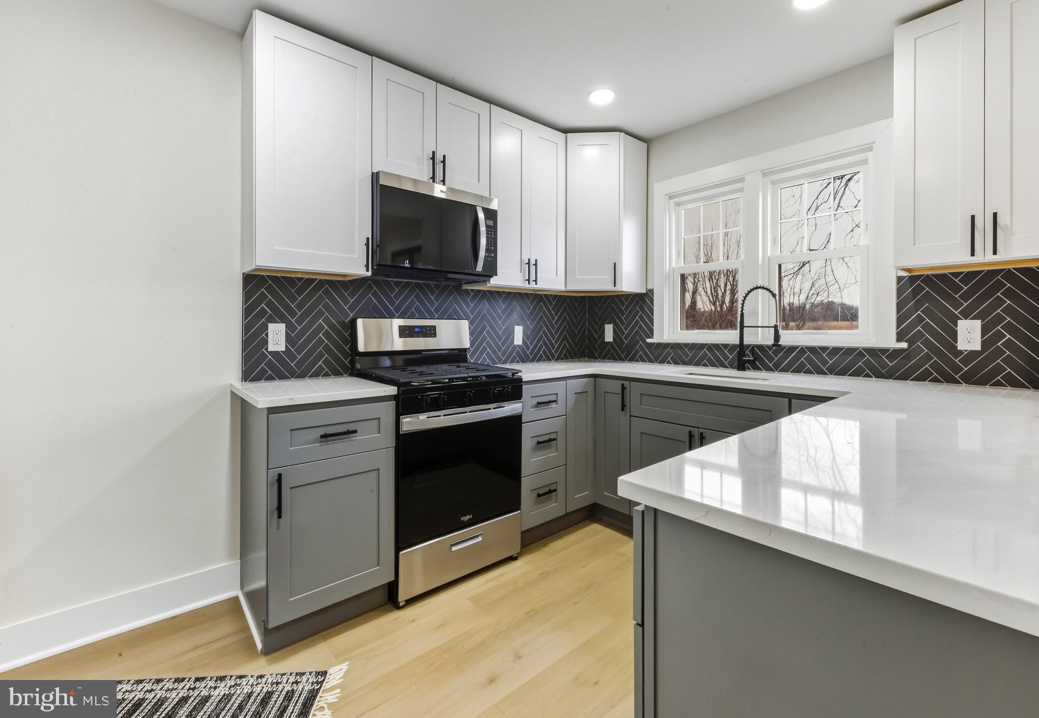 a kitchen with a sink stove and microwave