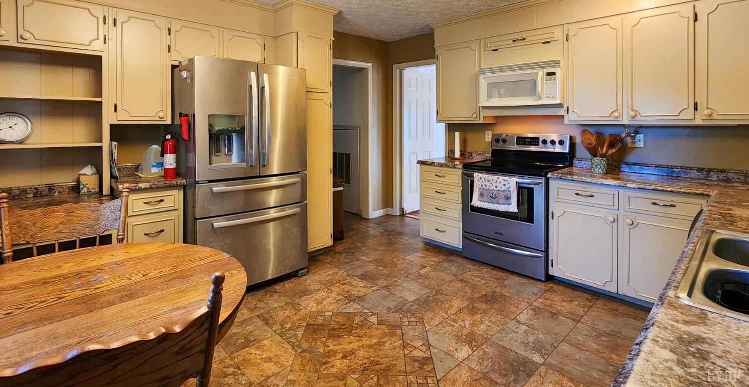 109 Juniper Cliff Road Brookneal, VA 24528 - Photo 8 of 13 a kitchen with stainless steel appliances granite countertop a refrigerator sink and stove top oven