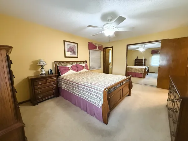 a spacious bedroom with a bed and ceiling fan