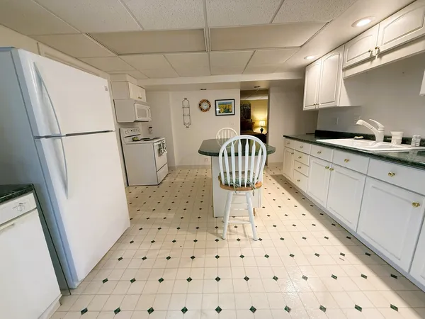 a kitchen with sink a refrigerator and cabinets