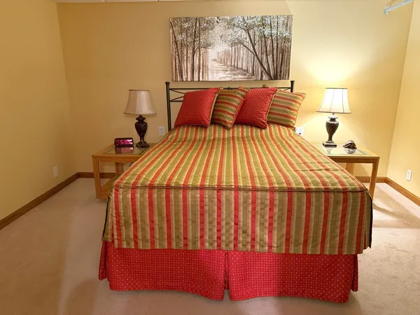 a bedroom with a bed and painting on the wall