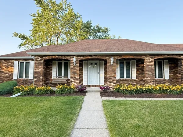 a front view of a house with a big yard and potted plants