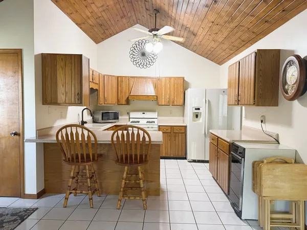 a kitchen with stainless steel appliances a table chairs and a refrigerator