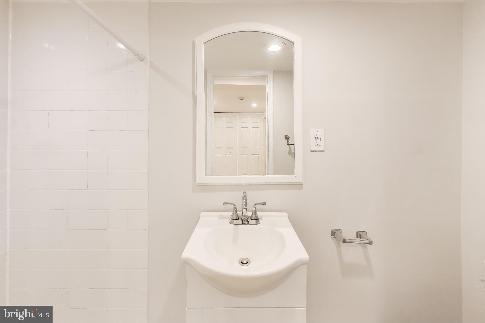 628 Madison Street Northwest Washington, DC 20011 - Photo 26 of 47 a bathroom with a sink and a mirror