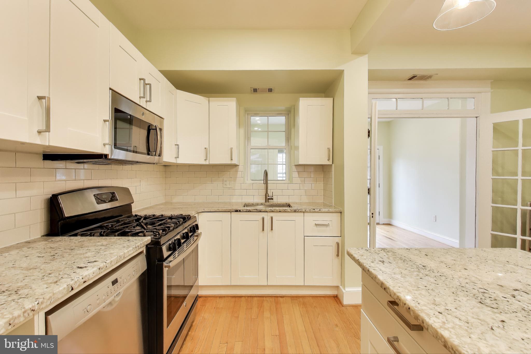 628 Madison Street Northwest Washington, DC 20011 - Photo 7 of 47 a kitchen with stainless steel appliances granite countertop a stove a sink and a microwave