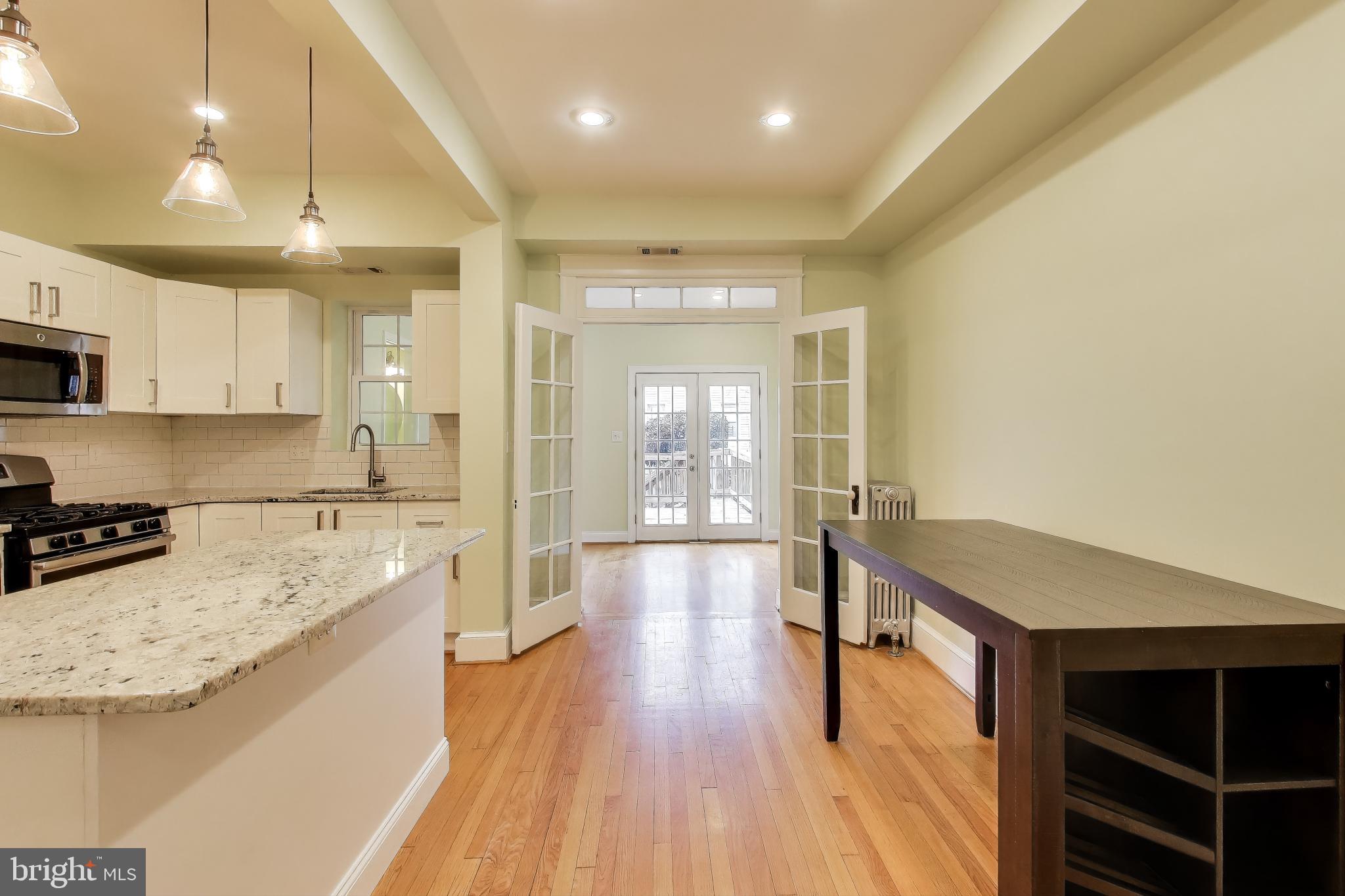 628 Madison Street Northwest Washington, DC 20011 - Photo 10 of 47 a open kitchen with kitchen island a sink stove and wooden floor