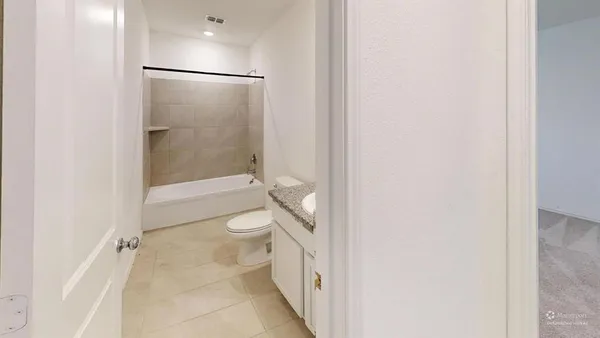 a bathroom with a granite countertop shower and a toilet