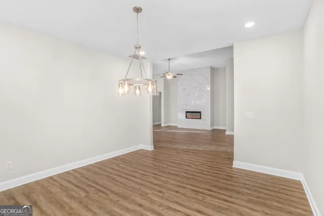 a view of empty room with wooden floor and ceiling fan