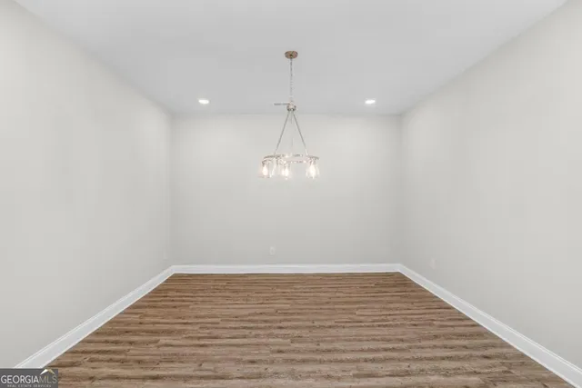 a view of a room with wooden floor and white walls