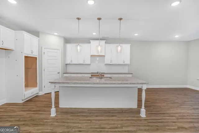 a kitchen with kitchen island a sink stainless steel appliances and cabinets