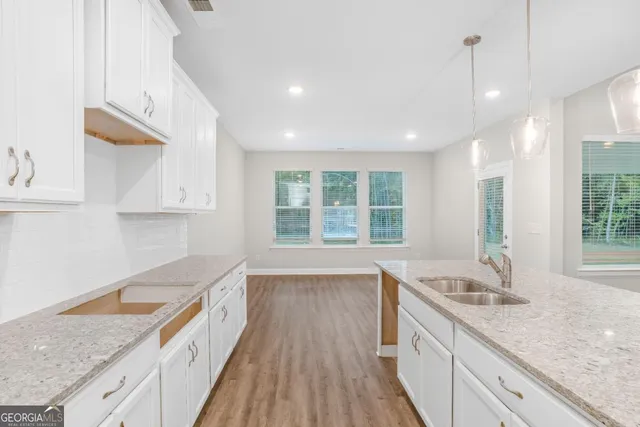 a kitchen with granite countertop a sink stove and cabinets