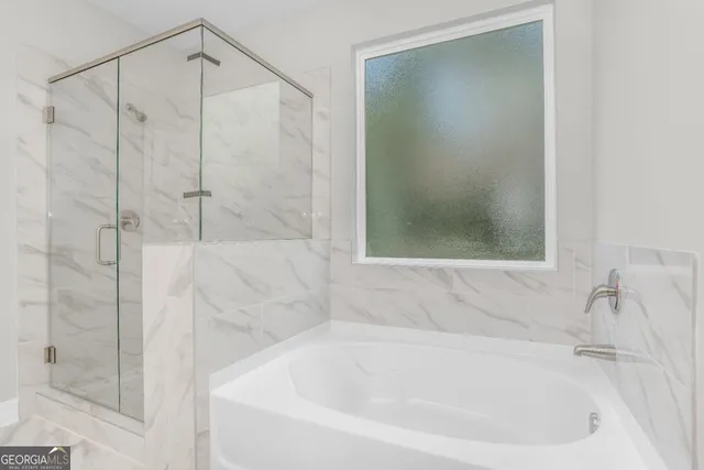 a white bath tub sitting next to a shower