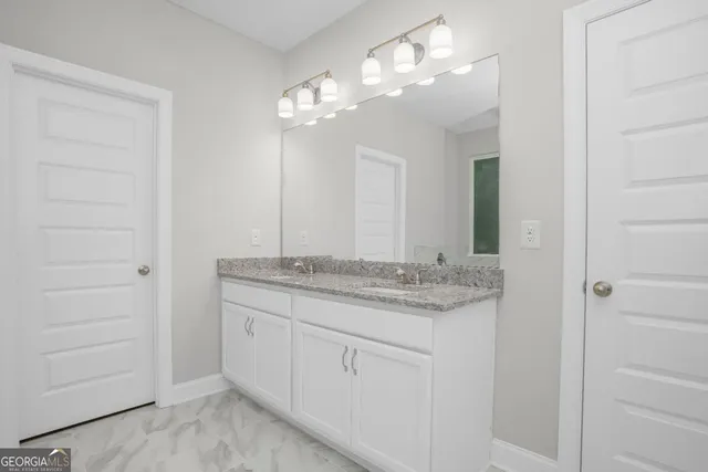 a bathroom with a granite countertop sink a mirror and a vanity