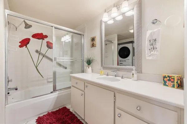 a bathroom with a sink mirror and a shower