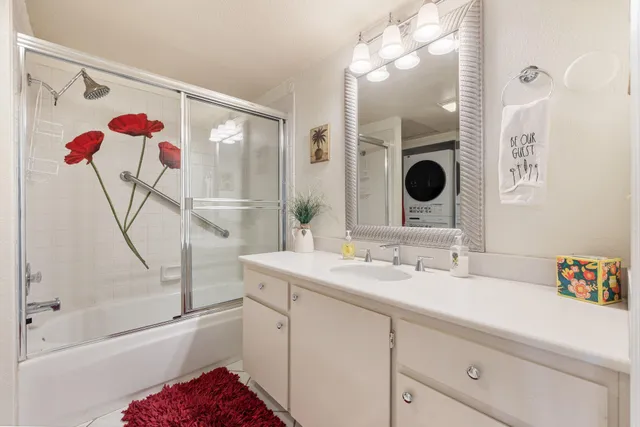 a bathroom with a sink mirror and a shower