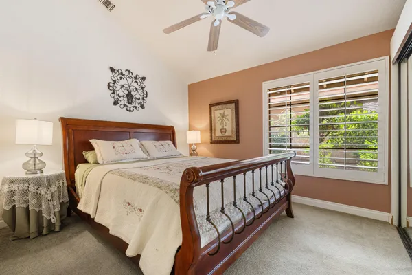 a bed sitting in a bedroom next to a window