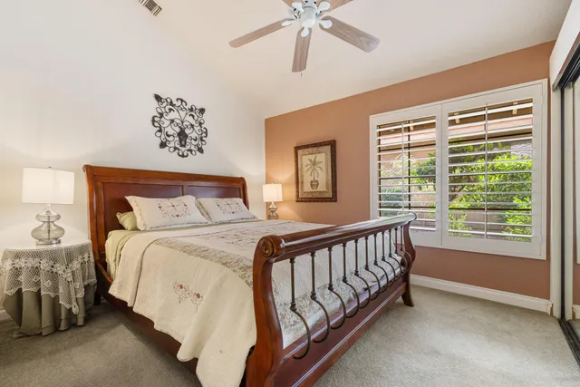 a bed sitting in a bedroom next to a window