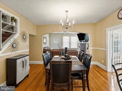 a view of a dining room with furniture a rug and wooden floor
