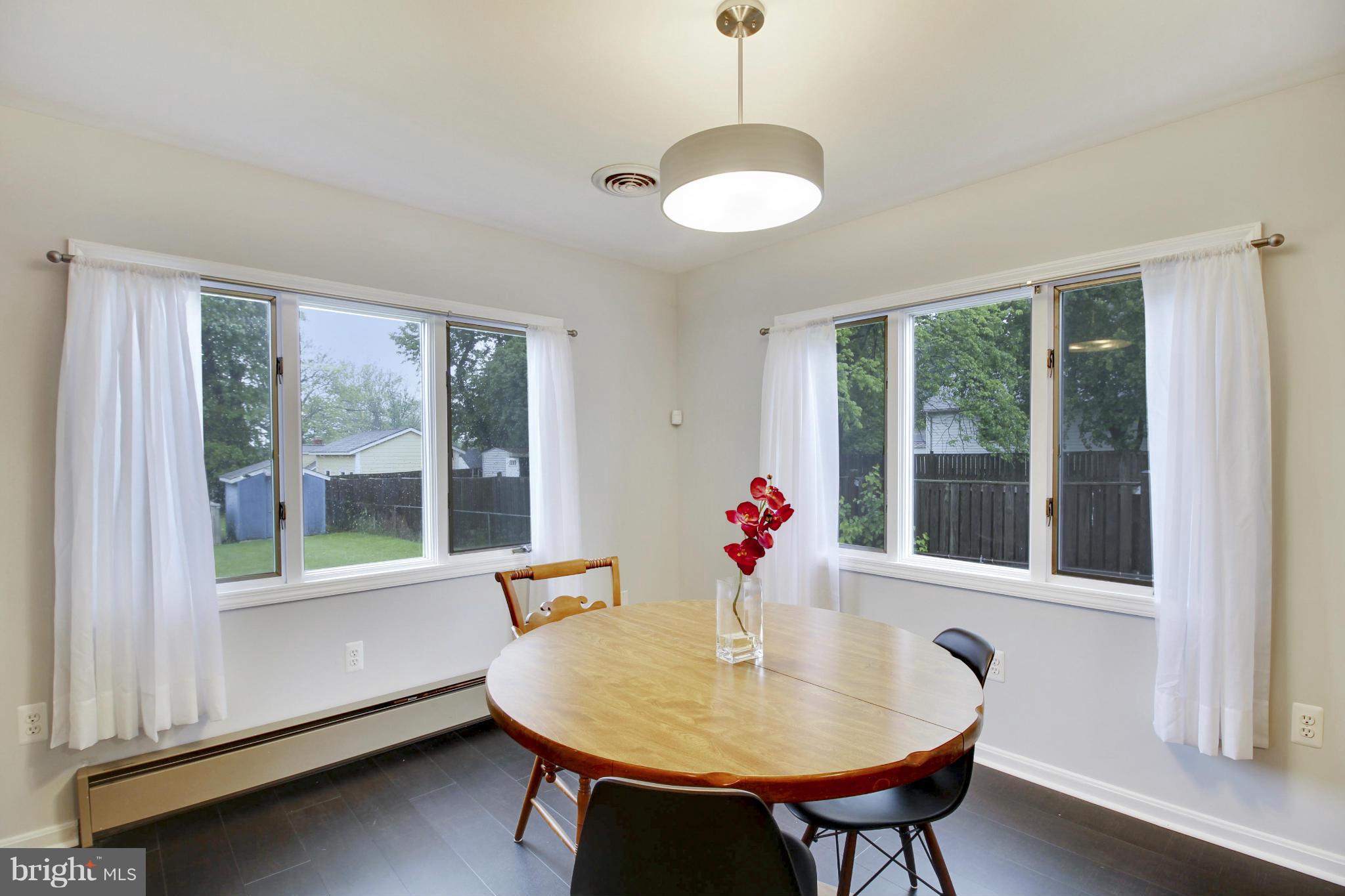 12128 Veirs Mill Road Silver Spring, MD 20906 - Photo 13 of 30 a dining room with furniture a chandelier and wooden floor