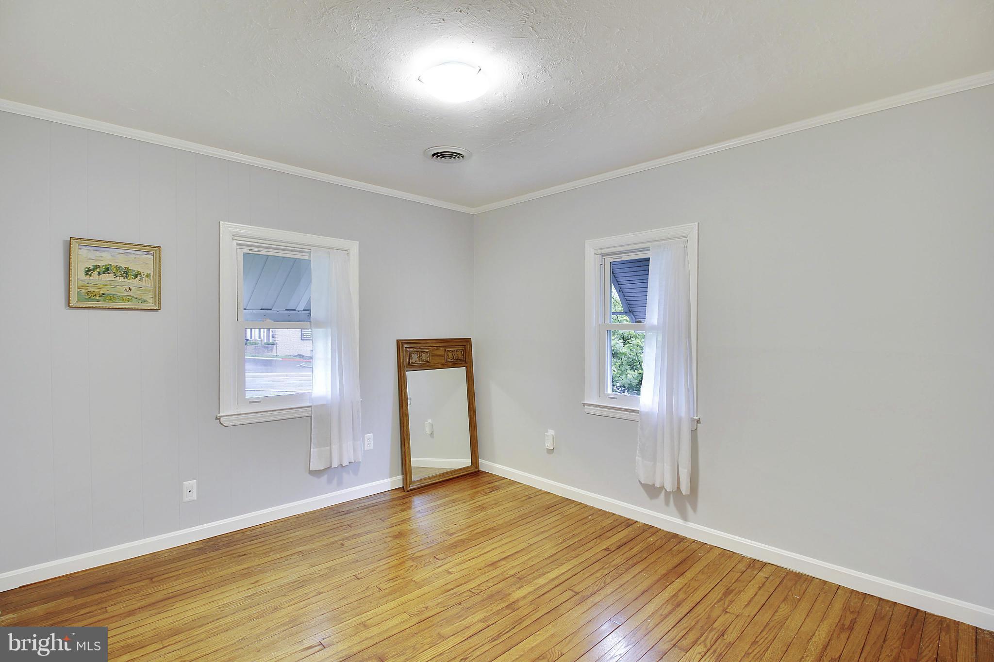 12128 Veirs Mill Road Silver Spring, MD 20906 - Photo 14 of 30 a view of empty room with wooden floor and fan