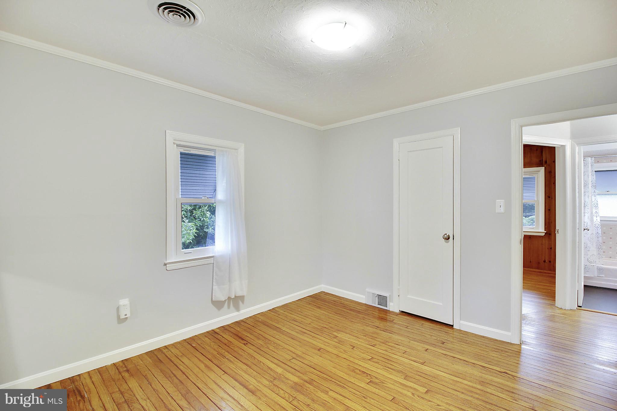 12128 Veirs Mill Road Silver Spring, MD 20906 - Photo 15 of 30 an empty room with wooden floor and windows