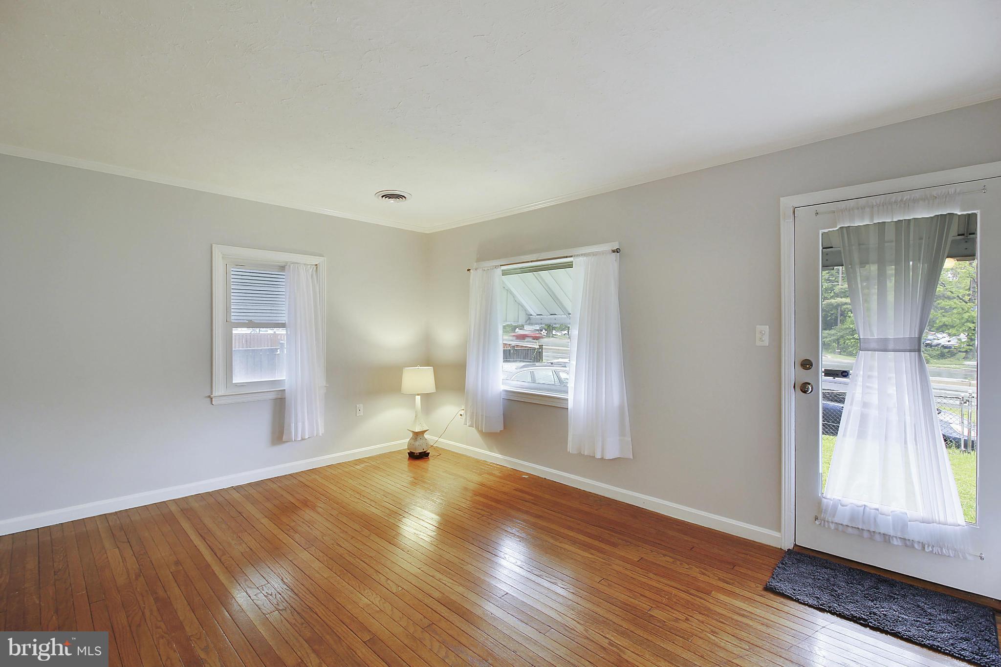 12128 Veirs Mill Road Silver Spring, MD 20906 - Photo 4 of 30 a view of empty room with wooden floor and fan