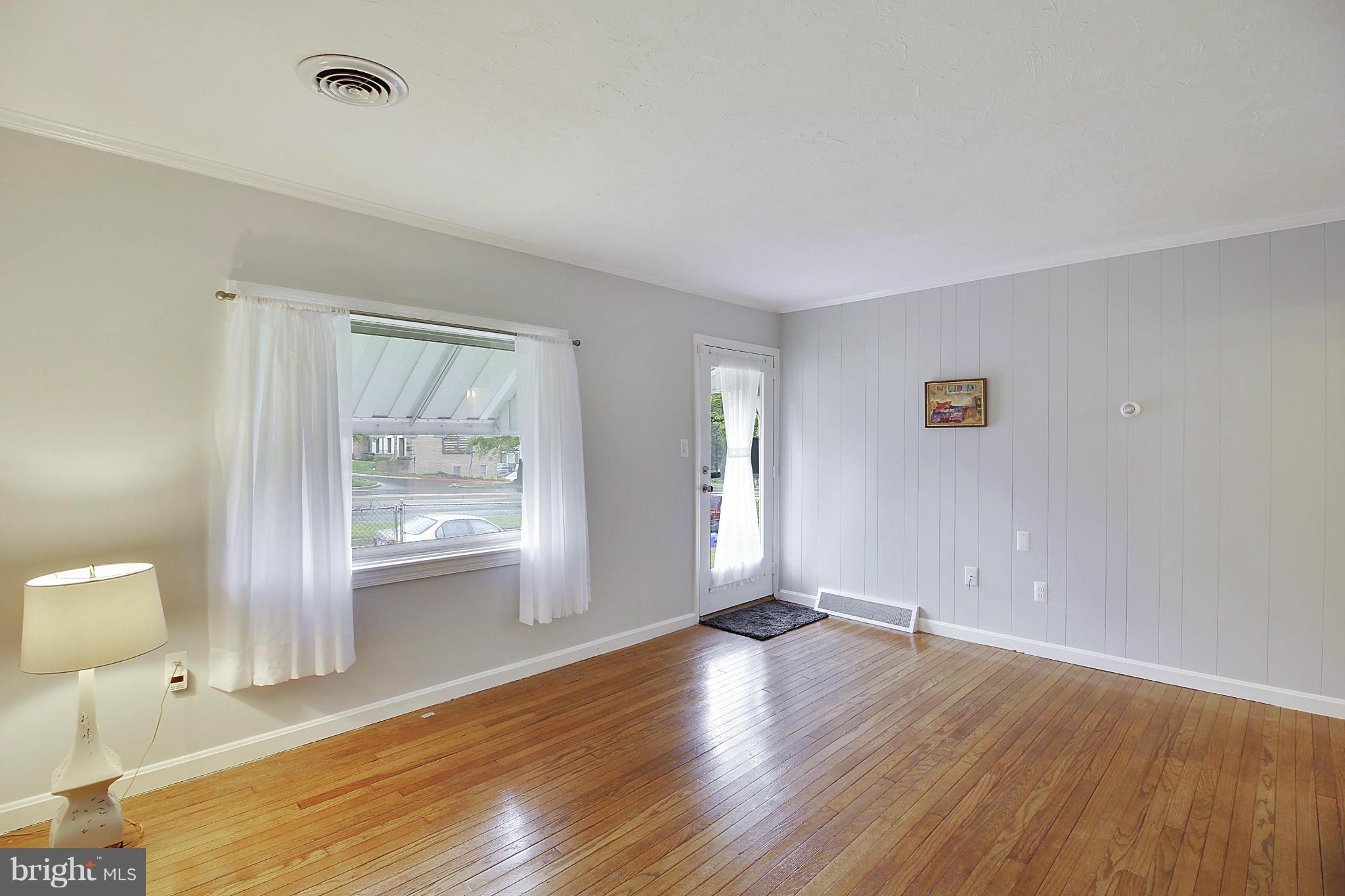 12128 Veirs Mill Road Silver Spring, MD 20906 - Photo 5 of 30 an empty room with wooden floor and windows