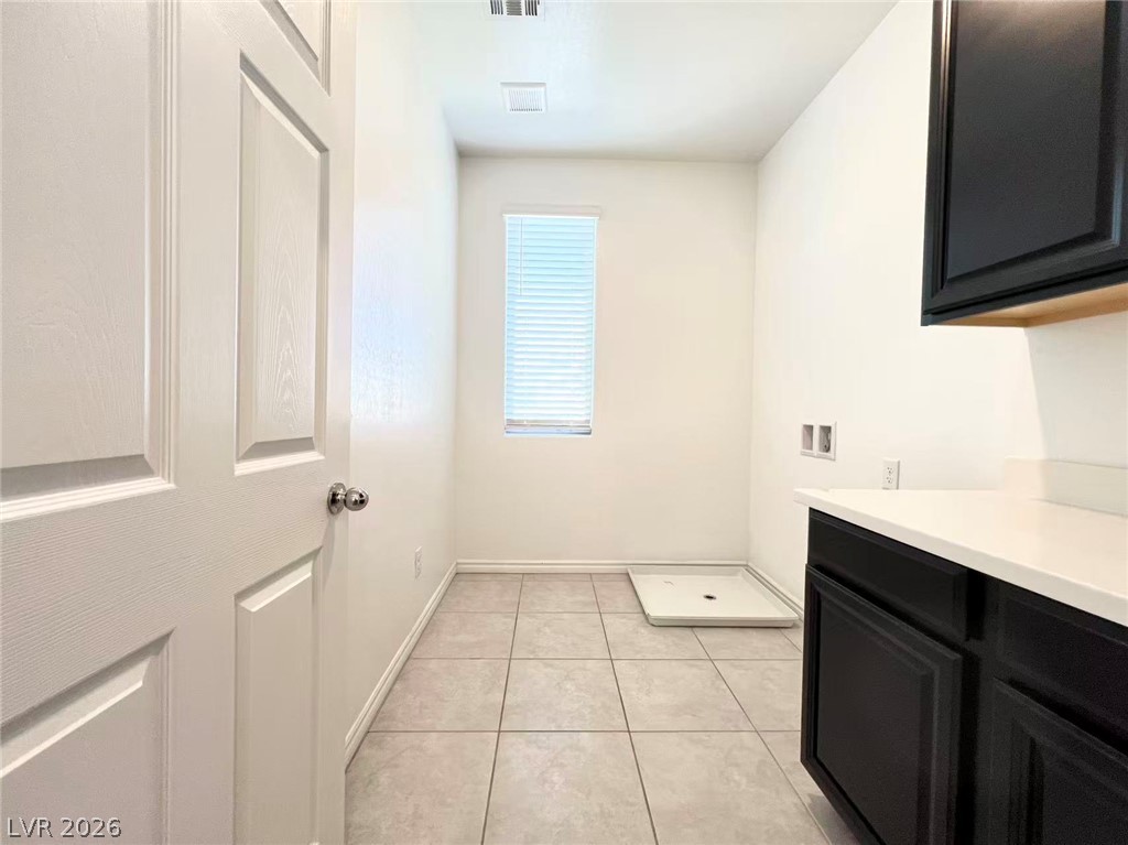 925 Bayberry Ridge Street Henderson, NV 89052 - Photo 25 of 27 Functional utility room with ample space, tiled floors, and a well-lit window.