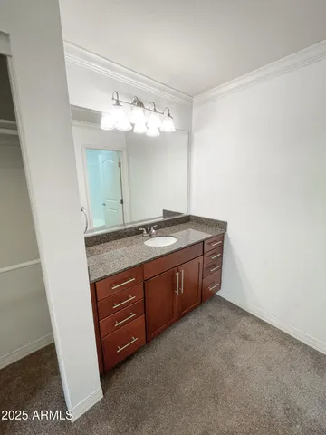 a spacious bathroom with a granite countertop sink and a mirror