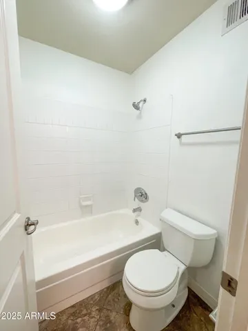 a white toilet sitting next to a bath tub