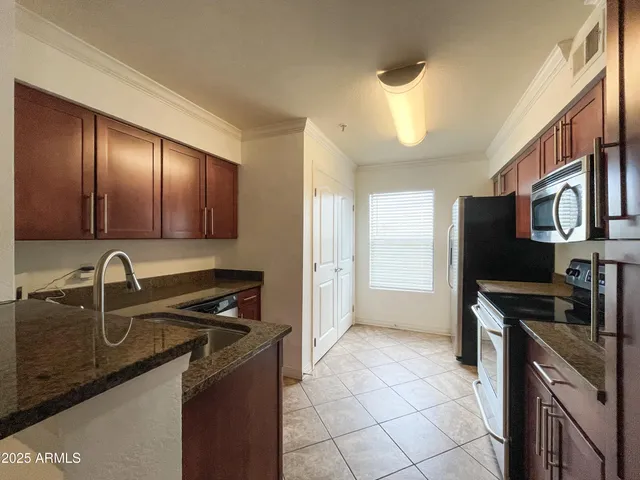 a kitchen with a sink a refrigerator and cabinets