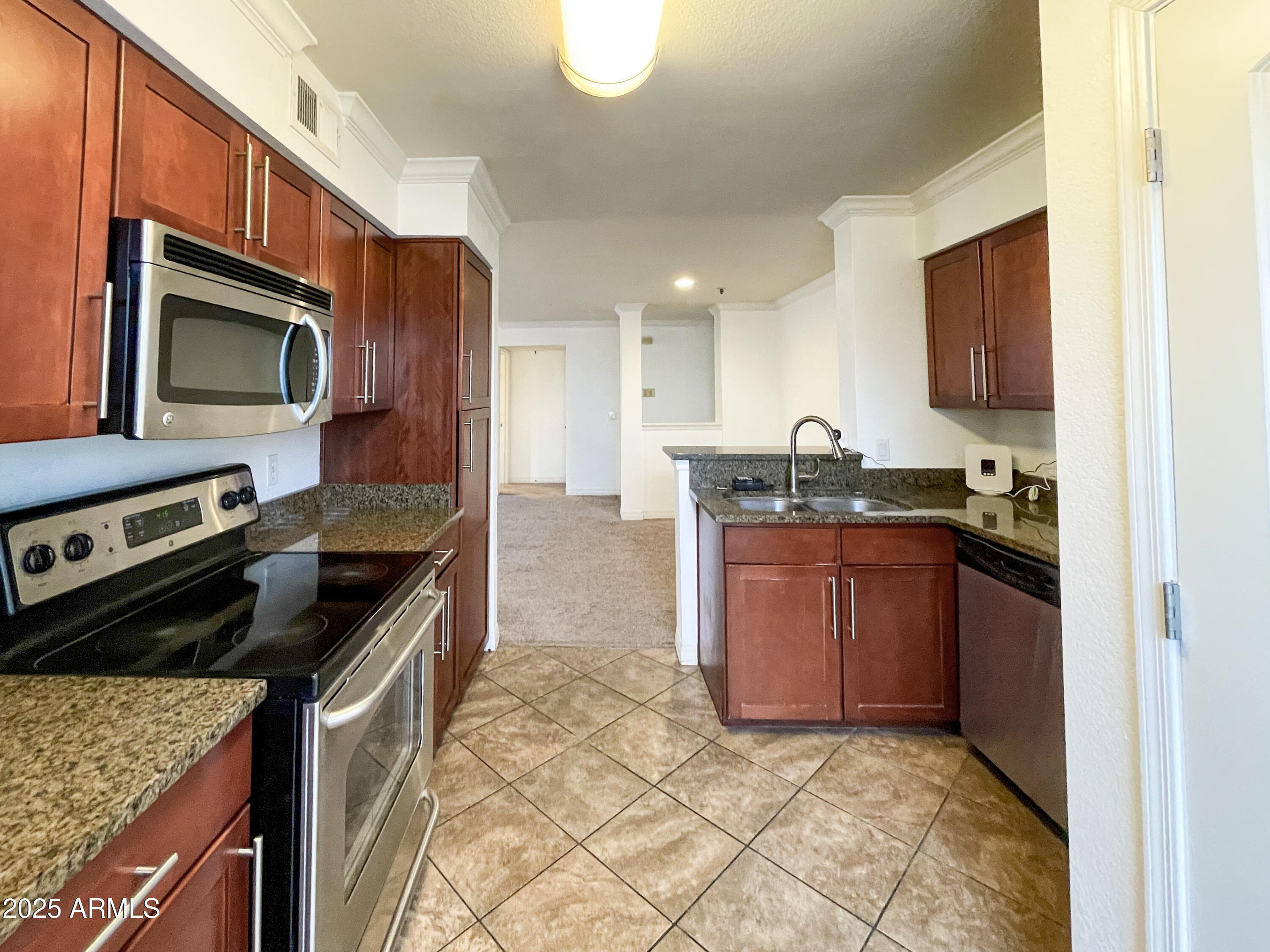 2025 East Campbell Avenue, Unit 312 Phoenix, AZ 85016 - Photo 4 of 16 a kitchen with stainless steel appliances granite countertop a stove microwave and sink