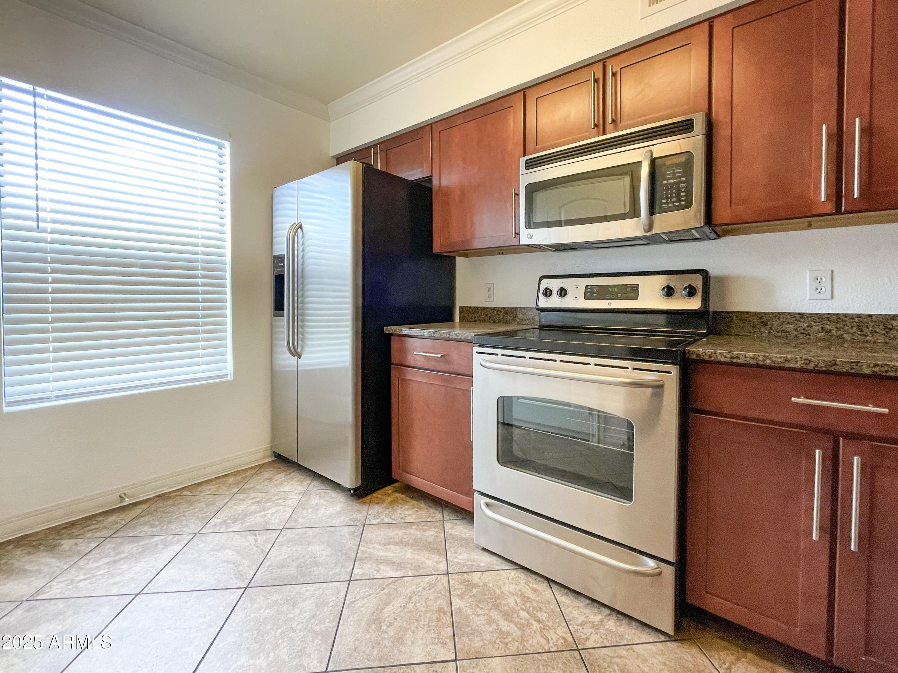 2025 East Campbell Avenue, Unit 312 Phoenix, AZ 85016 - Photo 5 of 16 a kitchen with granite countertop wooden cabinets stainless steel appliances and a window