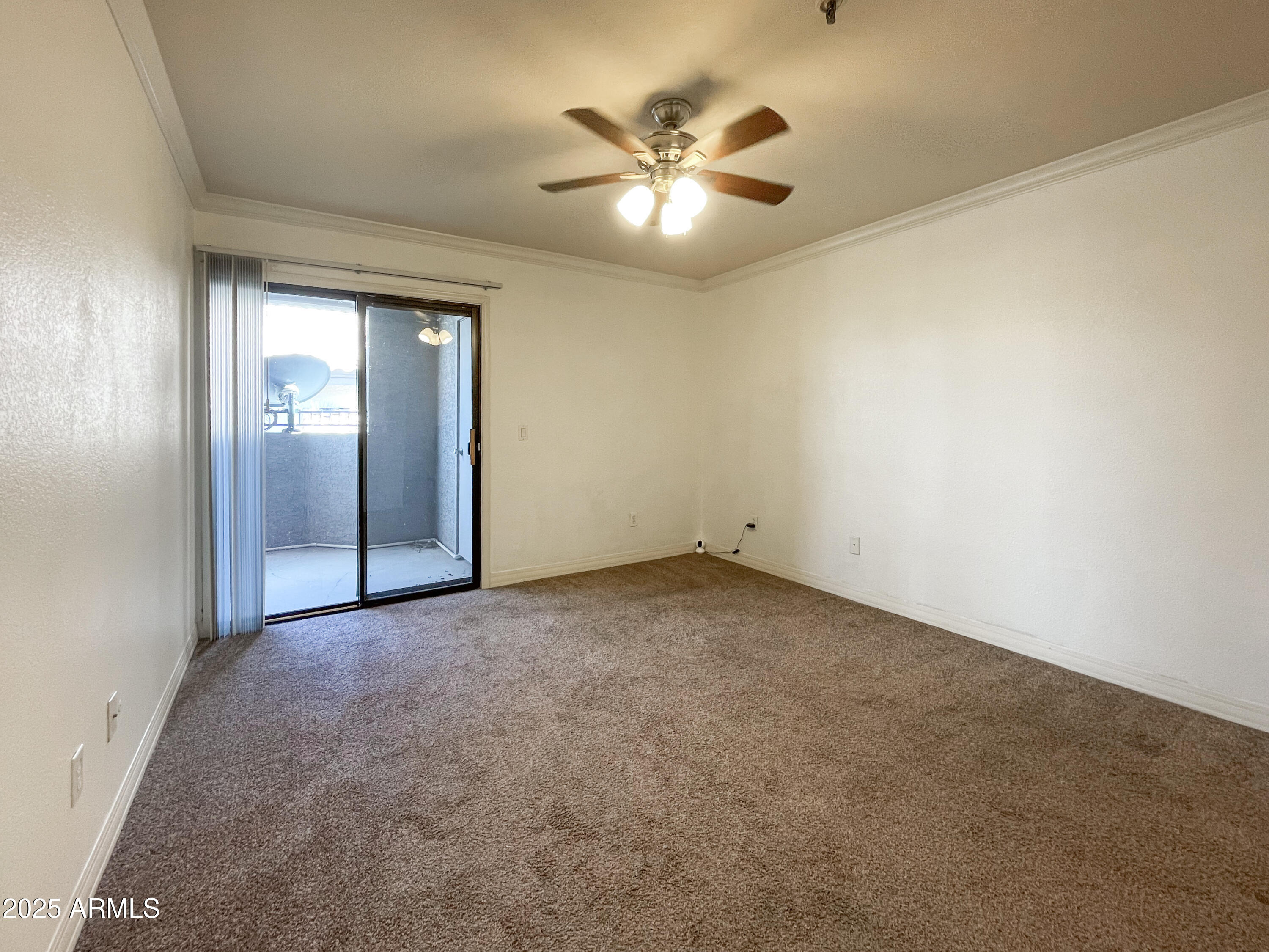 2025 East Campbell Avenue, Unit 312 Phoenix, AZ 85016 - Photo 9 of 16 an empty room with a chandelier fan and windows