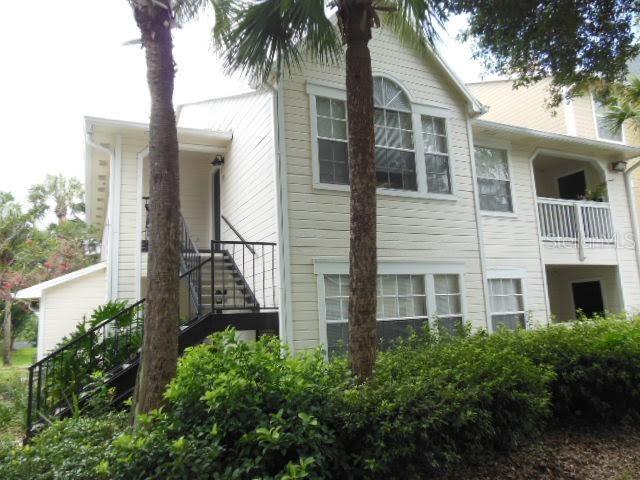 a front view of a house with a yard and potted plants