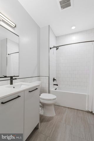 a bathroom with a bathtub a sink a toilet and a mirror