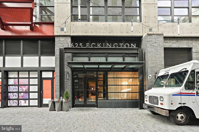 a view of a building with a cars park side of a road
