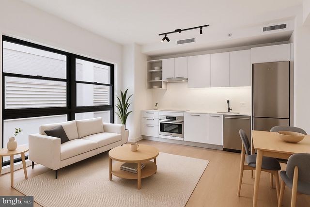 a living room with furniture and kitchen view