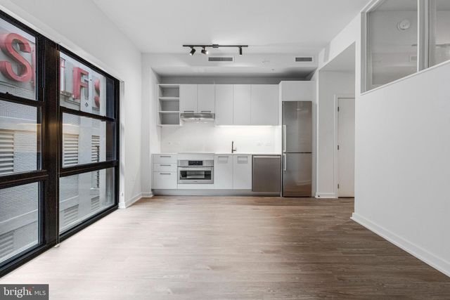 a view of a kitchen with furniture and wooden floor