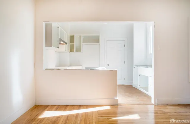 a view of a hallway with wooden floor and closet area
