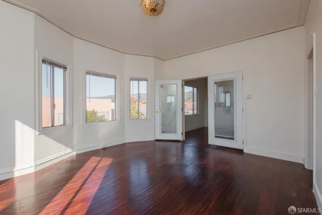 a view of an empty room with wooden floor