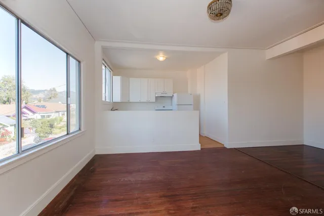 an empty room with wooden floor and closet